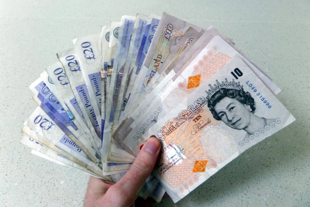 hand holding various pound notes