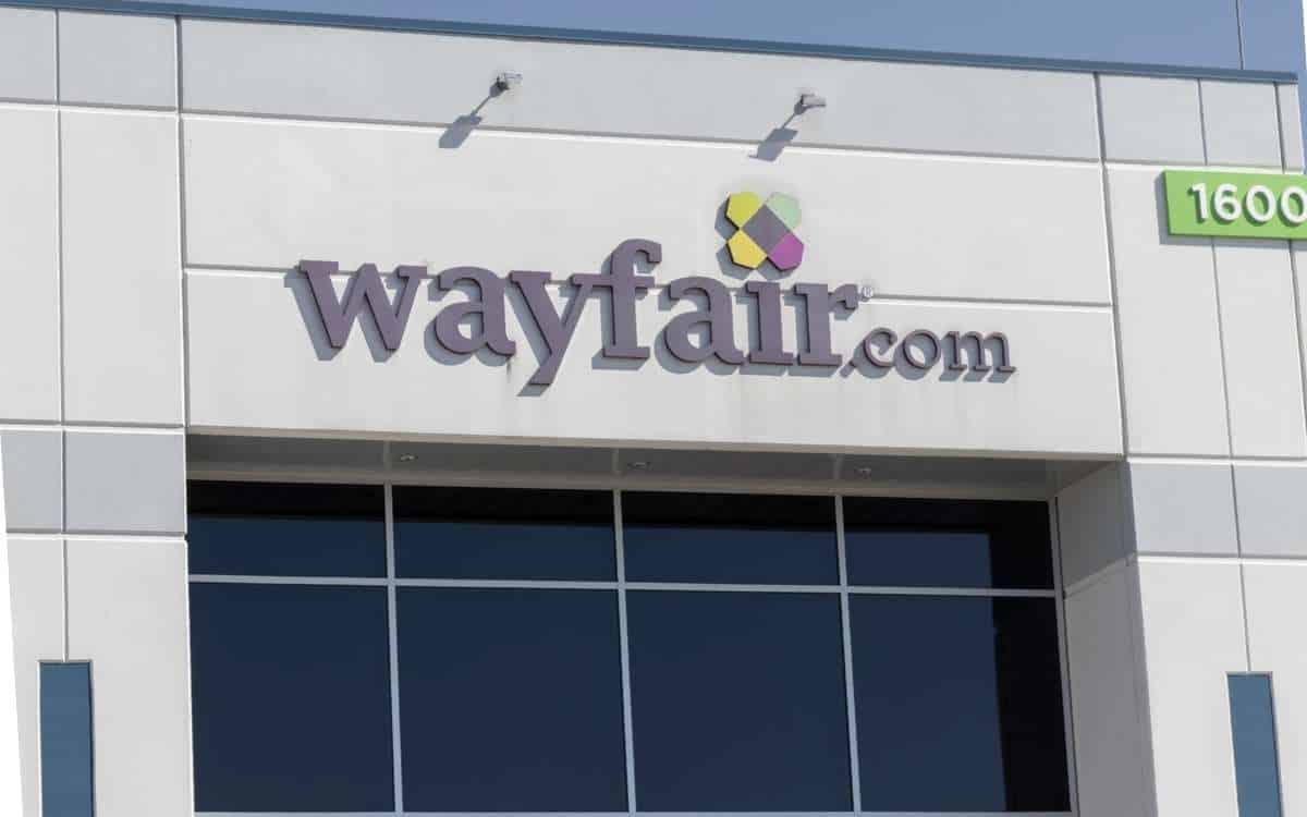 A building with large glass windows, grey wall with the word wayfair.com