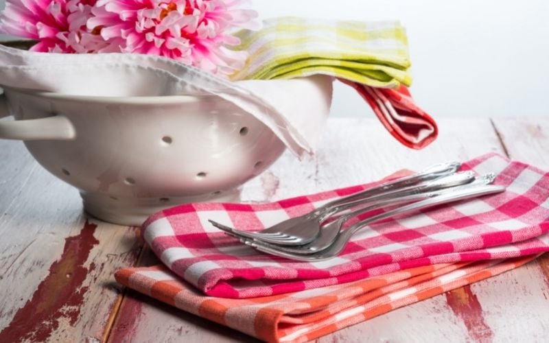 Photo of cloth napkins in different colors with forks and a bowl